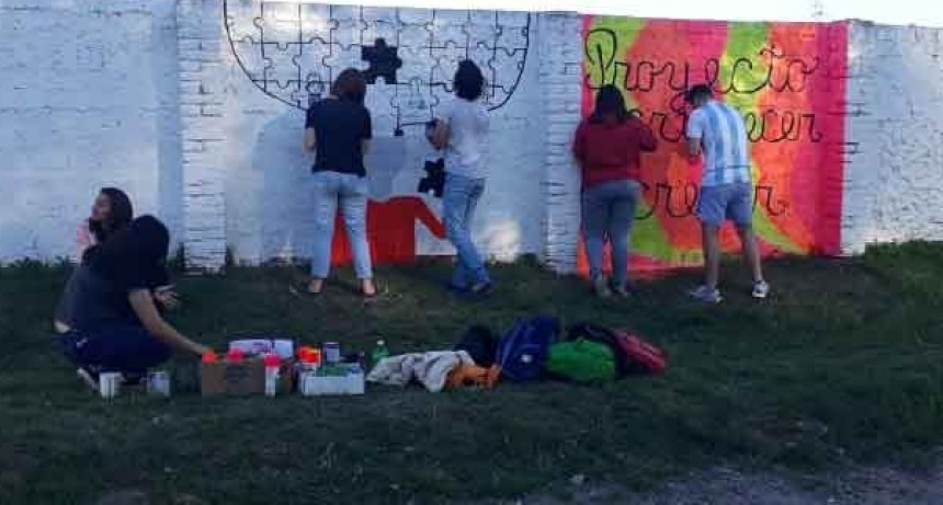 Estudiantes de la preparatoria se encuentran pintando un mural